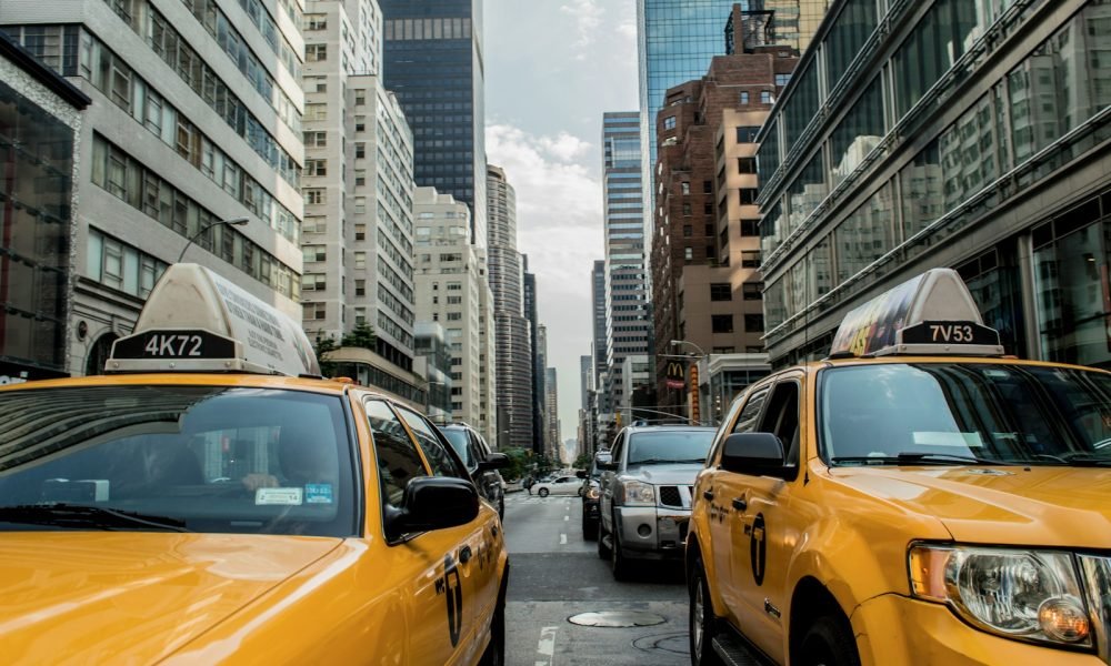 two yellow cars between buildings