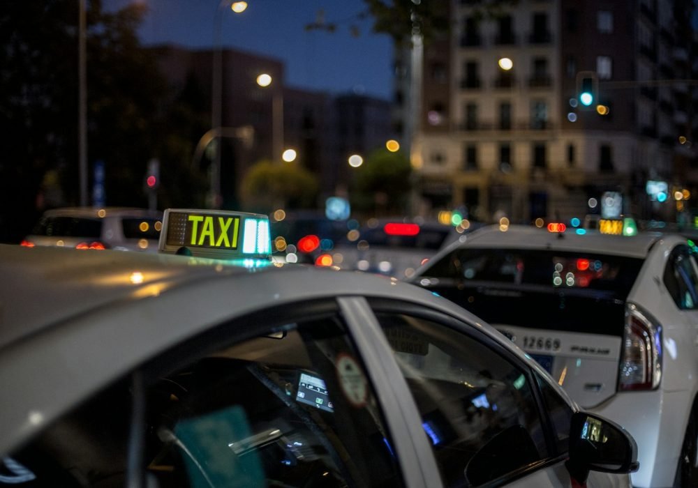white and black taxi cab on road during night time